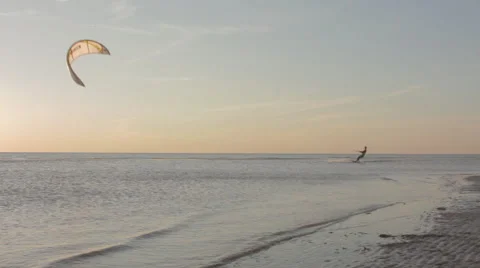 Kite surfer surfing at ocean at sunset wide shot pan 2 Stock Footage 44392379