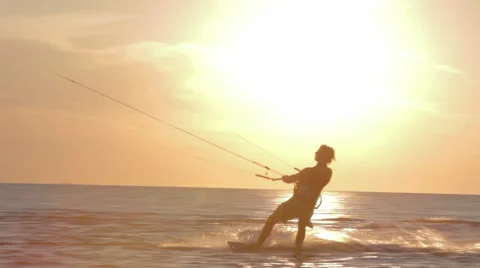 Kite surfer surfing at ocean at sunset medium shot pan Stock Footage 44393984