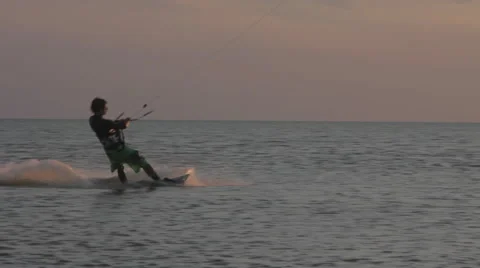 Kite surfer surfing at ocean at sunset medium shot pan 2 Stock Footage 44394373