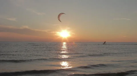 Kite surfer surfing at ocean at sunset wide shot pan 5 Stock Footage 44395534