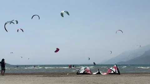 Kite surfers on ocean waves under sunny sky, Stock Footage 327551369