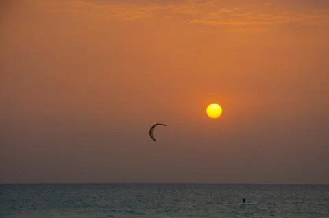 Kite surfing at sunset Stock Photos