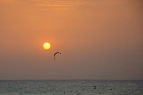Kite surfing at sunset Stock Photos