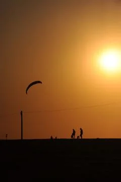 Kite surfing while sunset Stock Photos