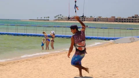 Kite surfing young man. Young tanned sportsman walking for his kitesurf board Video stock 164496551