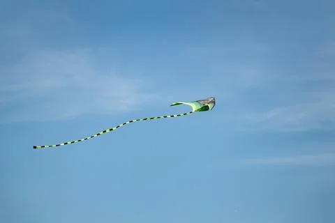 Kite toy with long tail fly in sunny blue sky Stock Photos