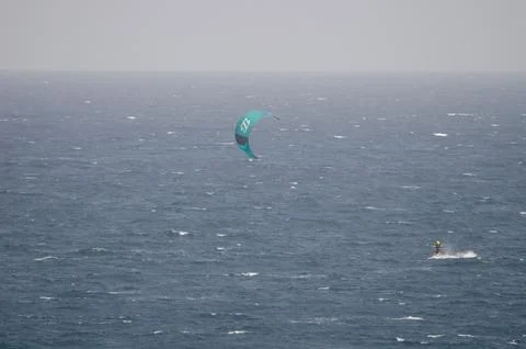 A kiteboarder being pulled by a power kite. Stock Photos