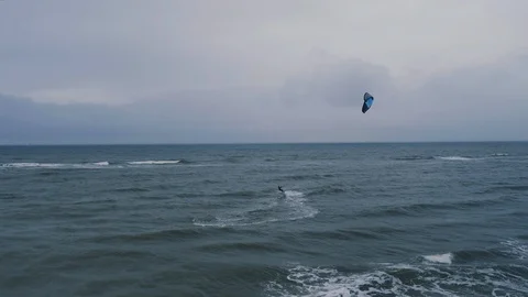 A kiteboarder surfs on the waves of the open North Sea near Zandvoort Stock Footage 100765169