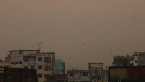 Kites Dot a Hazy Evening Sky Above Rooftops in Old Dhaka, Bangladesh Stockbeeldmateriaal 345294929