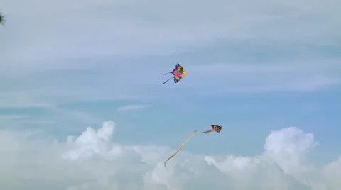 Kites fly in the sky with puffy clouds in background Stock Footage 37827084
