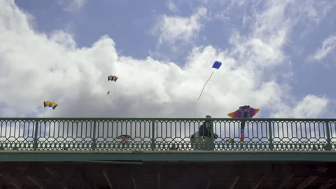 Kites hover above a victorian pier as tourists pass by Stock Footage 238665072
