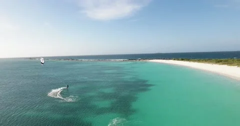Kitesurf jump, man makes difficult trick front white sand beach, Los Roques Vidéo 221990978
