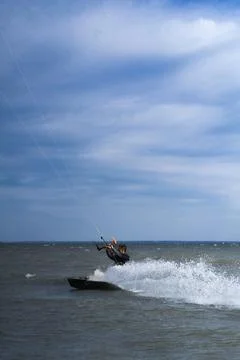 Kitesurfer creating water splash while riding at high speed on water Photos