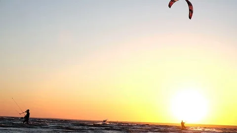 Kitesurfer does a trick in flight over the water against a sunset in summer Stock Footage 90642657