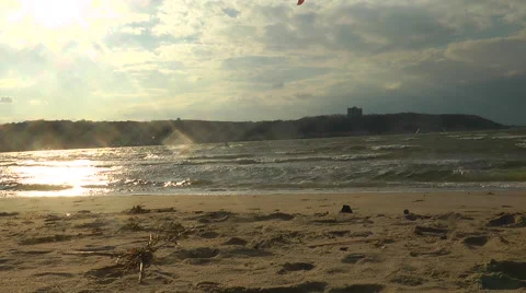 Kitesurfing on the beach, during sunset time.  Stockbeeldmateriaal 56462064
