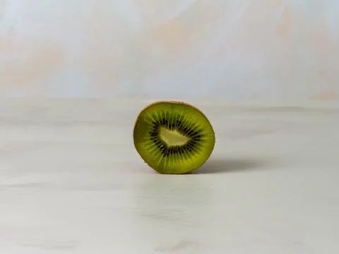 Kiwi cut in half, light background, green fruit, lots of vitamins, vegan food Stock Photos