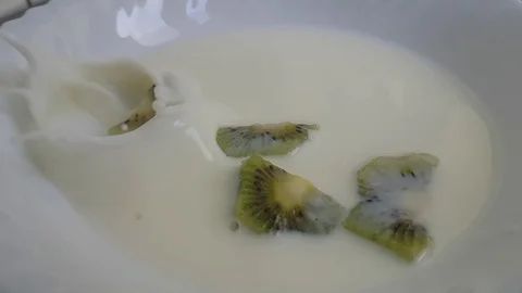 Kiwi falls into milk Stock Footage 88319721