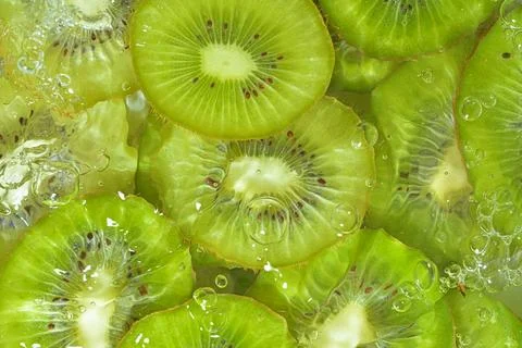 Kiwi fruit close-up in liquid with bubbles. Slices of gren ripe kiwi fruit in 스톡 사진