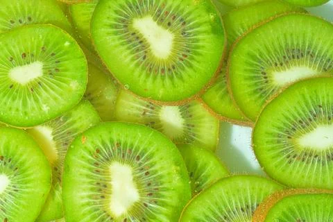 Kiwi fruit close-up in liquid with bubbles. Slices of gren ripe kiwi fruit .. Stock-Fotos