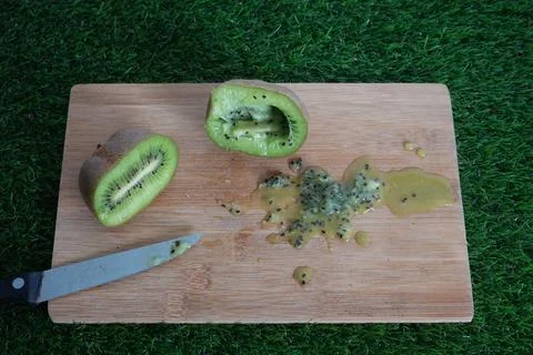 Kiwi fruit cut in half to remove seeds for sowing. kiwi seeds on the board Stock Photos