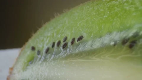 Kiwi fruit macro shooting,isolated half kiwi on yellow background rotates Stock Footage 130995395