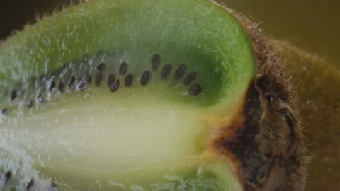 Kiwi fruit macro shooting,isolated half kiwi on yellow background rotates Stock Footage 130995451