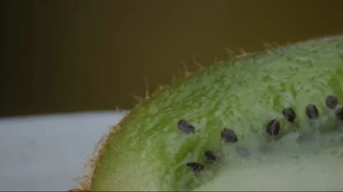 Kiwi fruit macro shooting,isolated half kiwi on yellow background rotates Stock Footage 131602566
