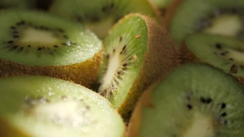 Kiwi fruit. Macro shot camera pans down and showing cutting kiwi fruits in Видео 171895821
