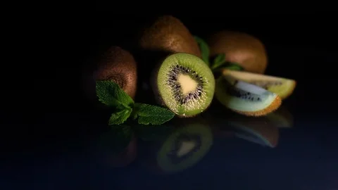 Kiwi fruit rotates on a table on a black background. Video stock 89961327