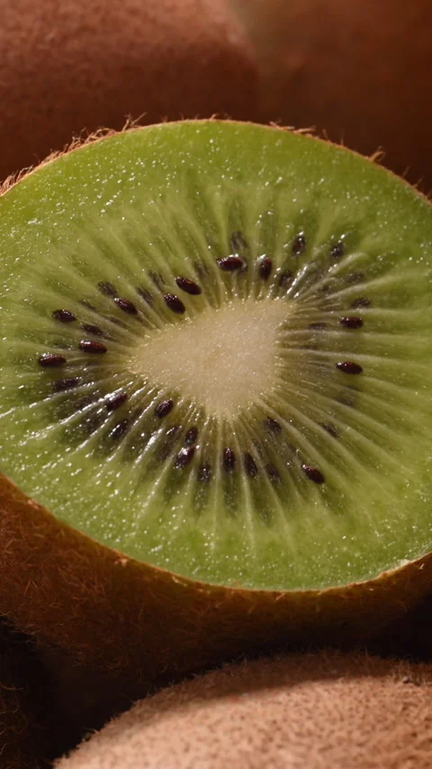 Kiwi half macro, sunlight on green flesh, fresh juice wellness background. 스톡 동영상 332220379