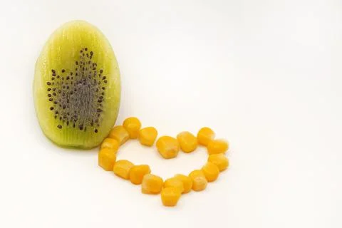 Kiwi in the shape of an Easter egg is cut in half, the heart is made of corn Stock Photos