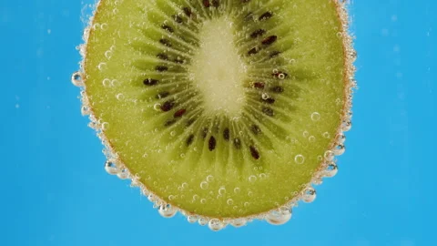 Kiwi slice on blue background. Cold lemonade cocktail. Ripe fruit close-up Stock Footage 197189553
