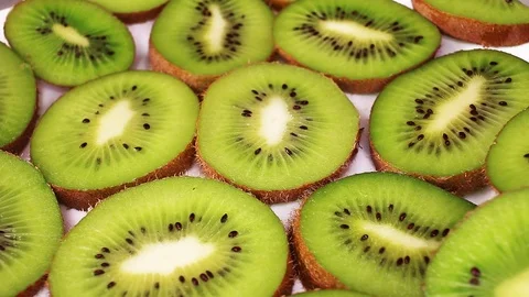 Kiwi slices texture pattern on rotating plate food hd video looping clip Stock Footage 98390314