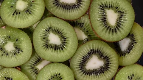 Kiwi Slices in Vortex Motion. Green Fruit Rotation on Black, Seamless 4K Loop Stock Footage 324918810