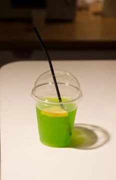 Kiwi soft drink with ice cubes and a slice of lemon Stock Photos