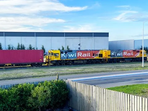 KiwiRail freight train with DXC 8007 locomotive and shipping containers pas.. Stock Photos