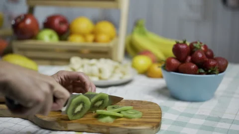 Kiwis being cut with sharp knife on cutting board - closeup shot Stock Footage 341216465