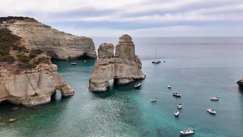 Kleftiko landmark sea stack and volcanic cliffs with motorboats on the Aegean Stock Footage 344919606