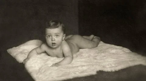 Kleinkind auf Eisbaerenfell, um 1920 Auf dem Bauch liegendes nacktes Klein... Stock Photos