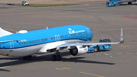 Klm boeing 737 being pushed back from gate by pushback truck amsterdam airport 스톡 동영상 283844518