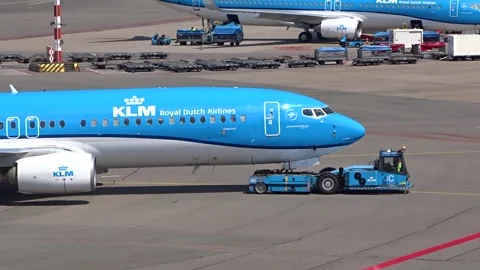 Klm boeing 737 being pushed back from gate by pushback truck amsterdam airport 스톡 동영상 283844701