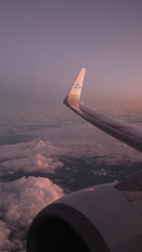 A KLM plane wing-tip in flight against a pink sunrise 4k @50fps Stock Footage 242026158