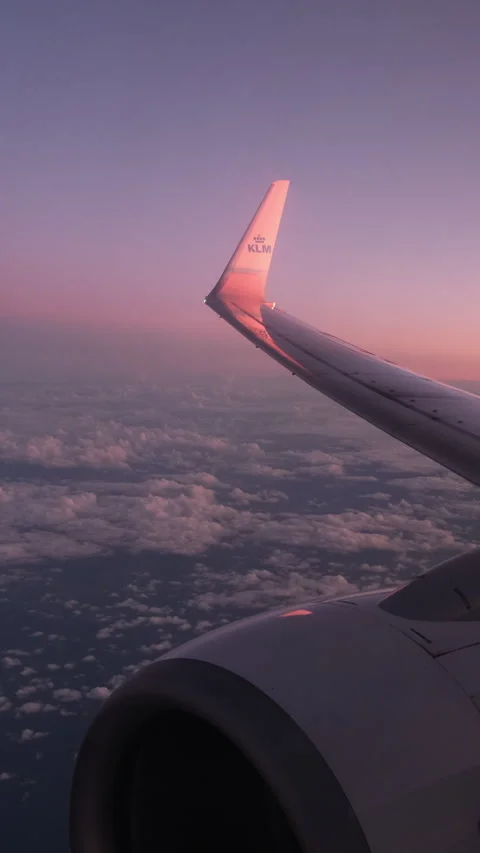 A KLM plane wing-tip in flight against a pink sunrise 4k @50fps Stock Footage 242026859
