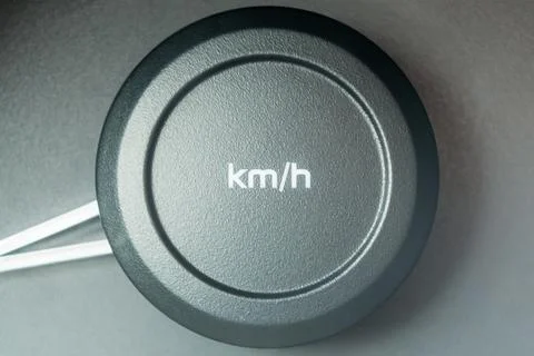 Kmh lettering on a round plastic button. Car speedometer. Stock Photos