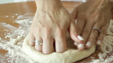 Knead the dough before baking. Hands roll out the dough on a wooden table Stock Footage 315028651