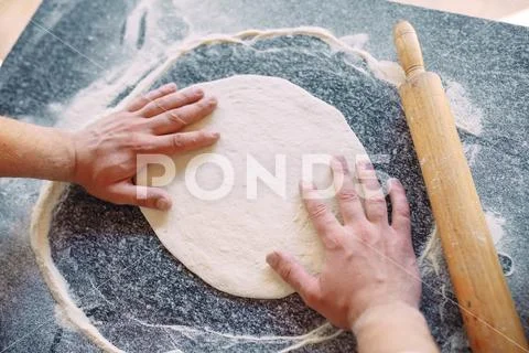 Knead the dough with the ingredients. Kitchen and pizza concept Stock Photos