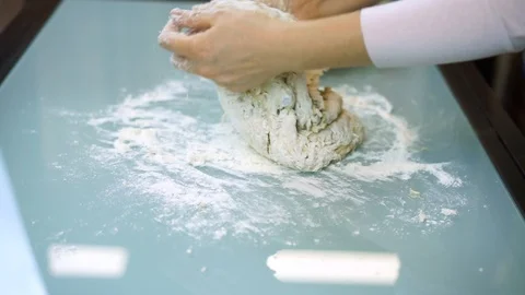 Knead flour dough on the table. Video stock 99631982