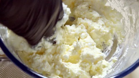 Kneading cottage cheese, egg and butter to make dough for cottage cheese cookies Stock Footage 299634123