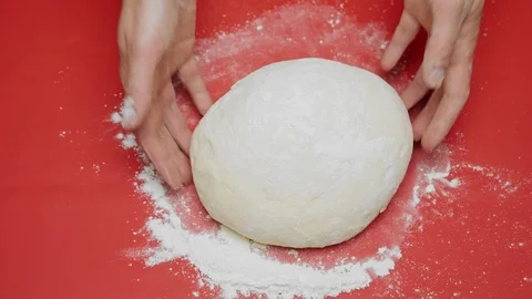 Kneading dough in flour on red table Stock Footage 95770271