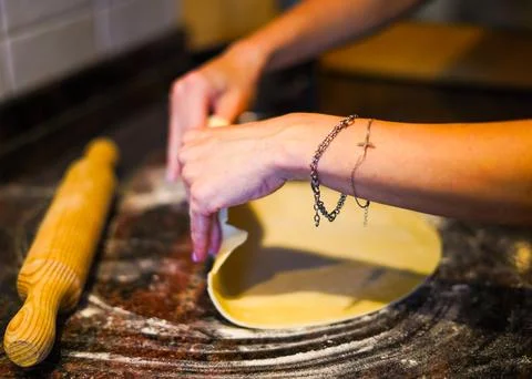Kneading a dough with a rolling pin with both hands Stock Photos